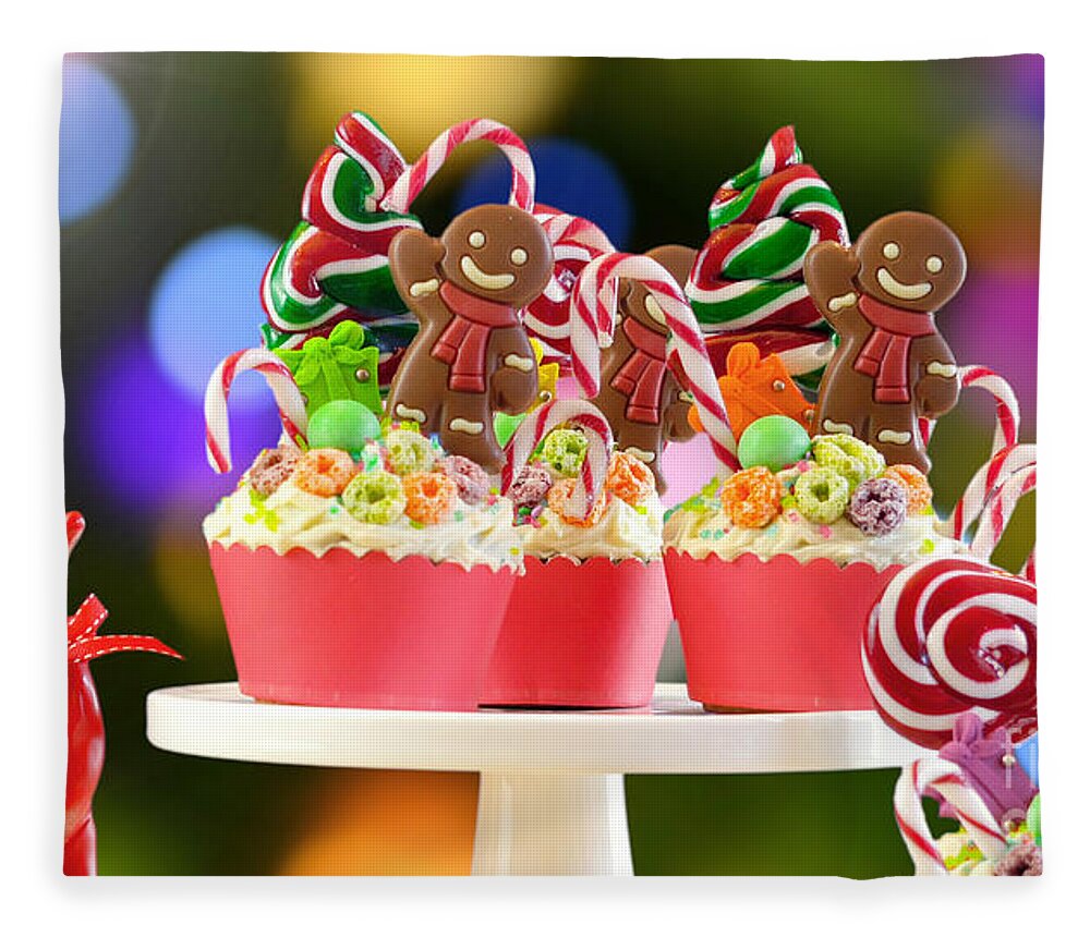 Christmas Fleece Blanket featuring the photograph On trend candy land festive Christmas cupcakes. by Milleflore Images