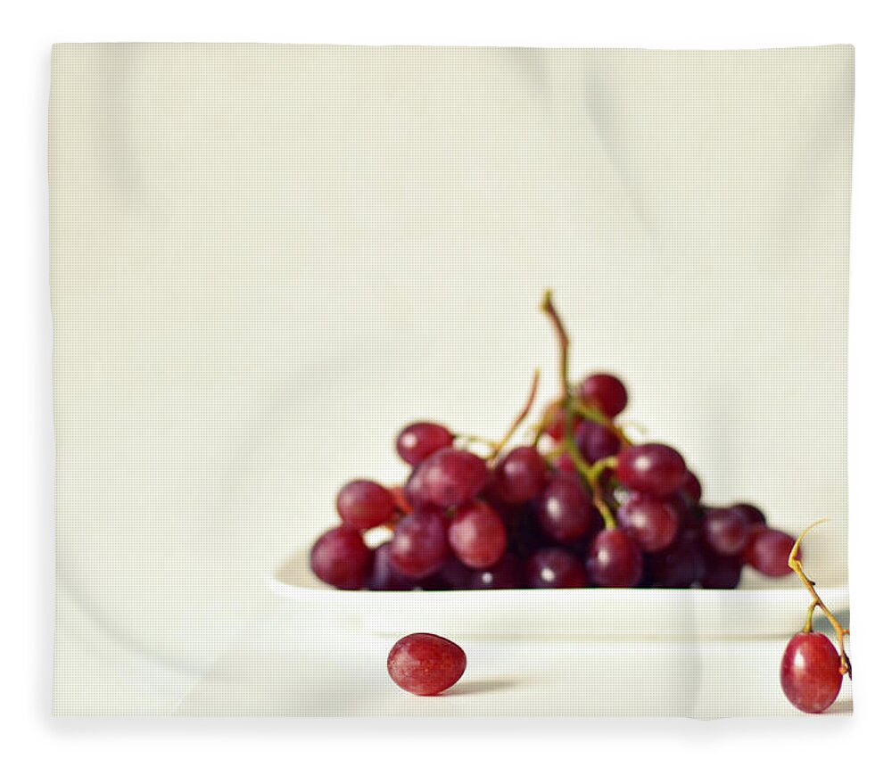 White Background Fleece Blanket featuring the photograph Red Grapes On White Plate by Photo By Ira Heuvelman-dobrolyubova