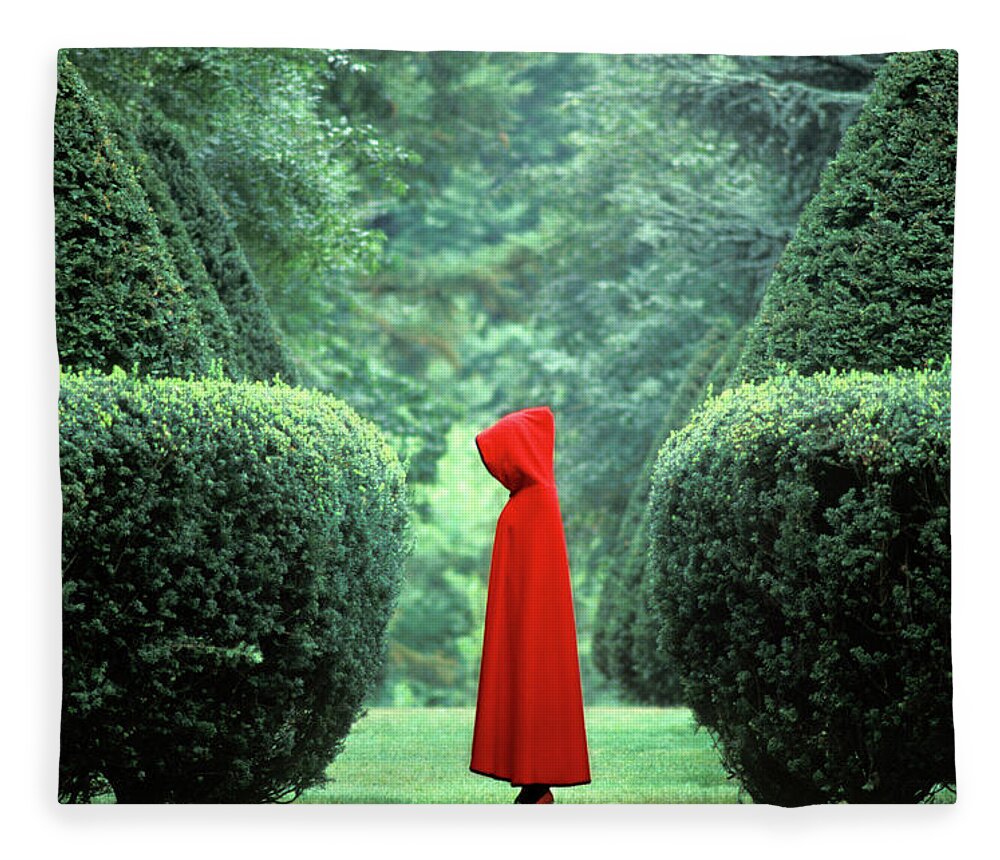 Topiary Fleece Blanket featuring the photograph Woman Wearing Red Cape Among Hedges by Nancy Brown