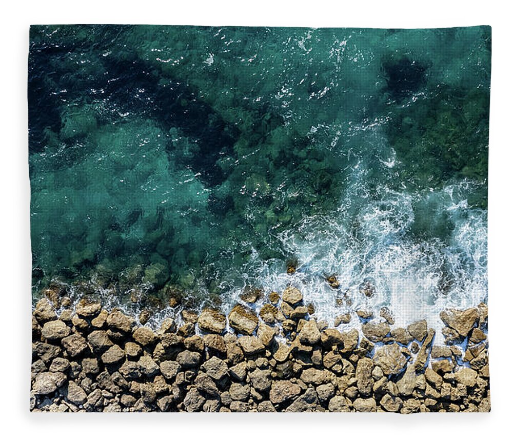 Seascape Fleece Blanket featuring the photograph Aerial view from flying drone of crystal blue ocean water and sea wall. by Michalakis Ppalis