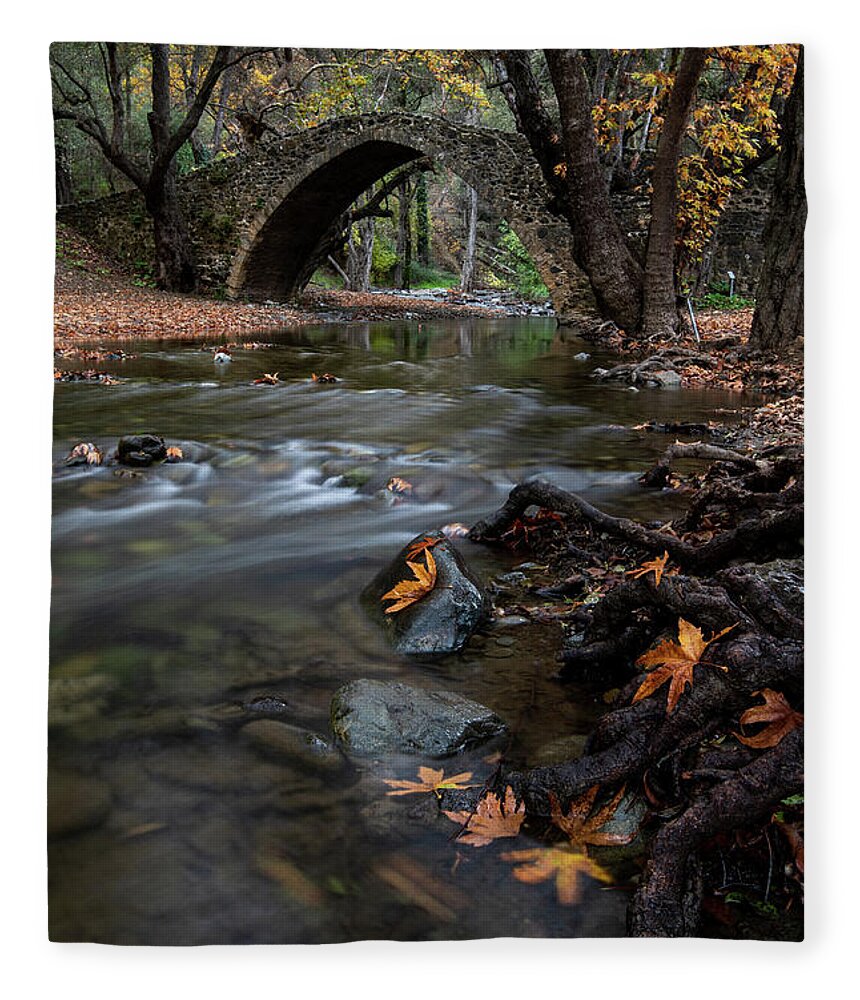 Autumn Fleece Blanket featuring the photograph Autumn landscape with river flowing under a stoned bridge by Michalakis Ppalis