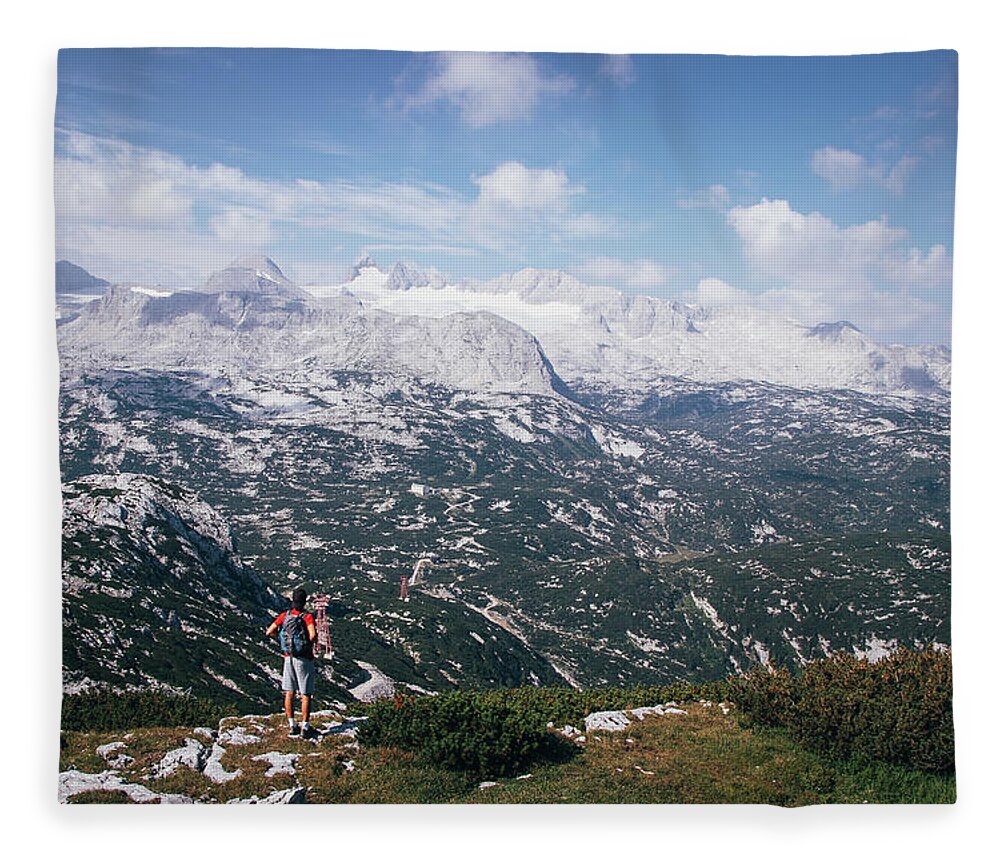 Sportive Fleece Blanket featuring the photograph Man with a backpack looks at the Dachstein massif by Vaclav Sonnek