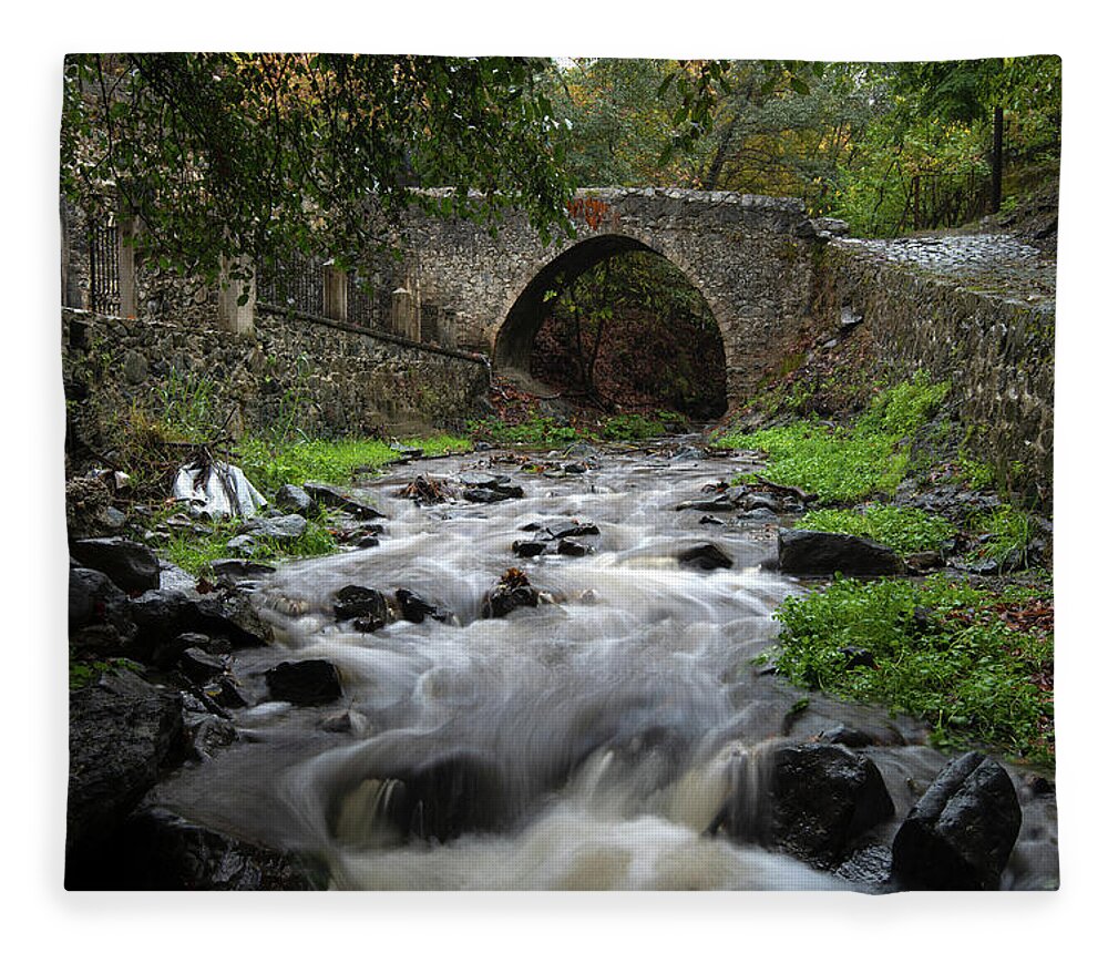 River Fleece Blanket featuring the photograph Medieval stoned bridge water flowing in the river. by Michalakis Ppalis