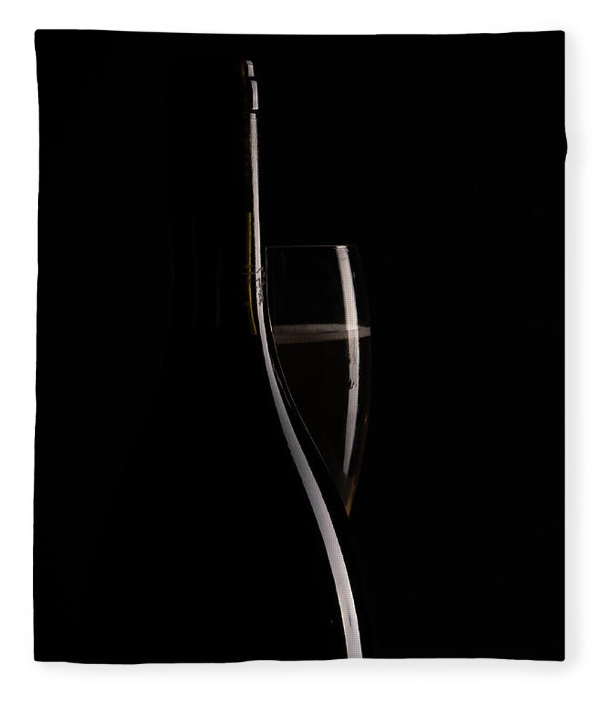 Red Wine Fleece Blanket featuring the photograph Red sparking wine on a wineglass and black wine bottle. by Michalakis Ppalis