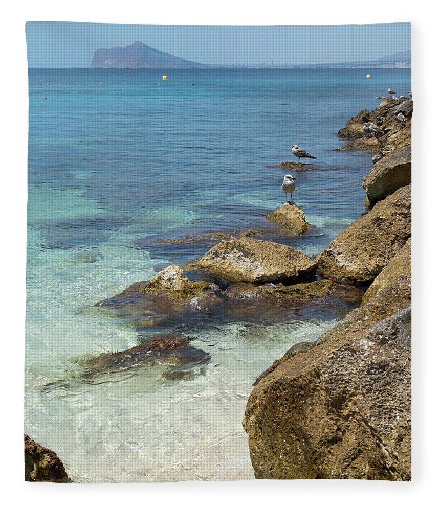 Mediterranean Fleece Blanket featuring the photograph Turquoise blue sea water and rocks in Calpe 2 by Adriana Mueller