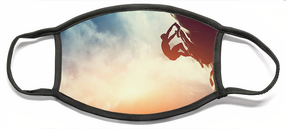 Climb Face Mask featuring the photograph A silhouette of man climbing on rock mountain by Michal Bednarek