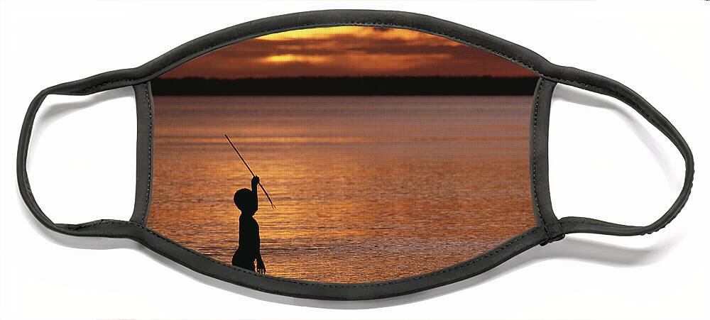 Mp Face Mask featuring the photograph Young Boy Spear Fishing At Sunset by Gerry Ellis