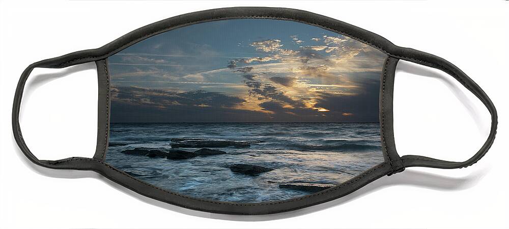 Sunset Over Sea Face Mask featuring the photograph Sunset on a rocky beach by Michalakis Ppalis
