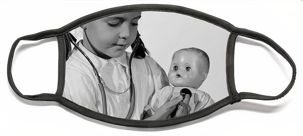 1960s Face Mask featuring the photograph Girl Playing Nurse With Doll, C.1960s by H Armstrong Roberts ClassicStock