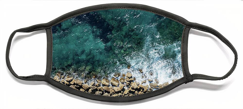 Seascape Face Mask featuring the photograph Aerial view from flying drone of crystal blue ocean water and sea wall. by Michalakis Ppalis