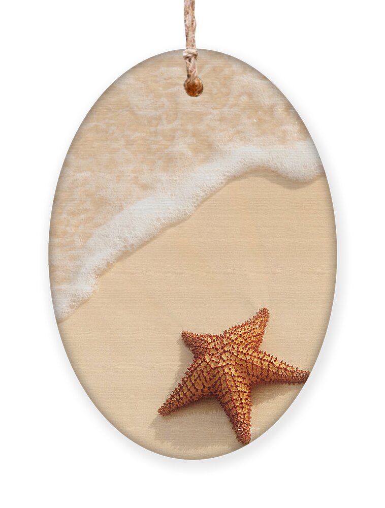 Starfish Ornament featuring the photograph Starfish and ocean wave by Elena Elisseeva