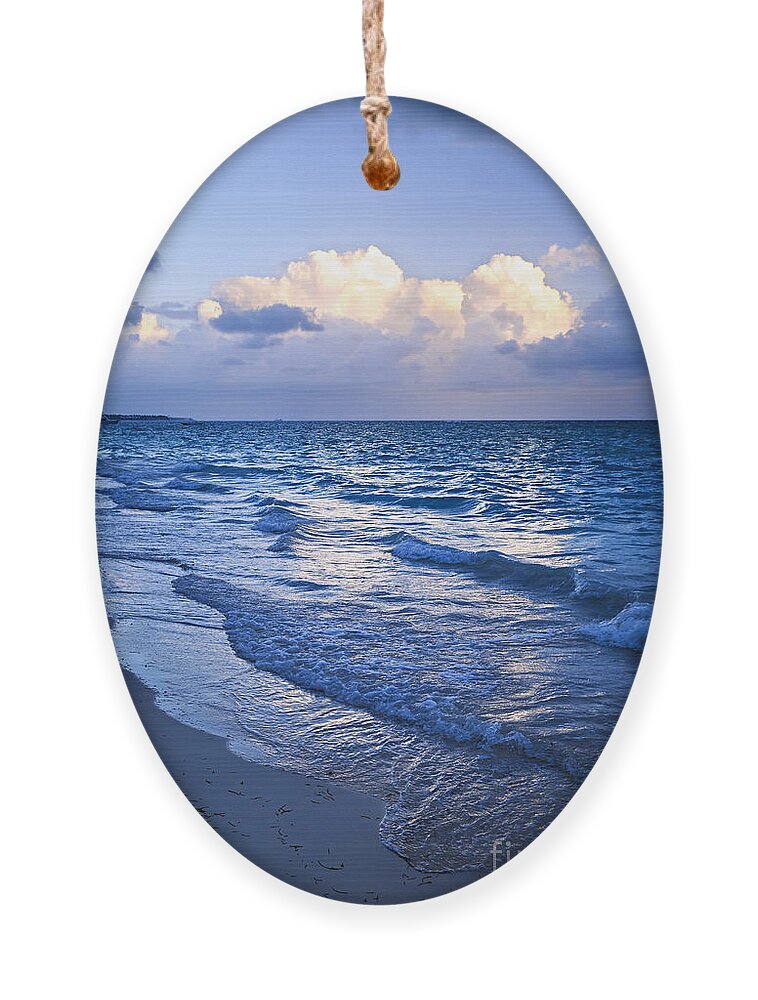Sunrise Ornament featuring the photograph Ocean waves on beach at dusk by Elena Elisseeva