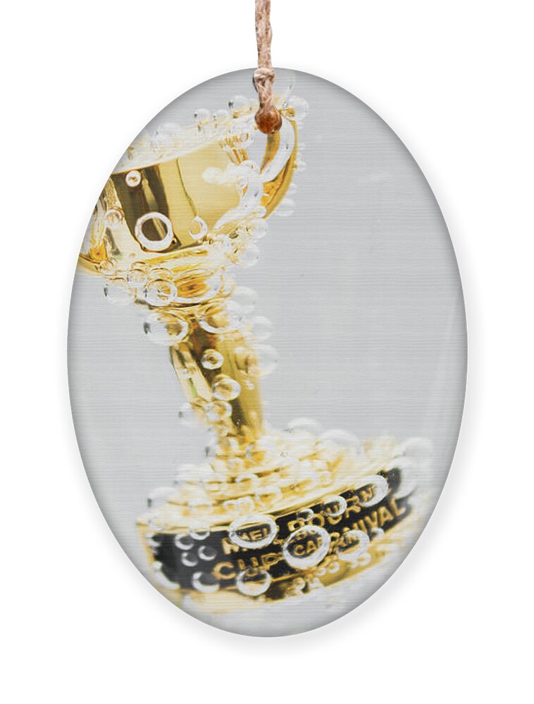 Horse Ornament featuring the photograph Closeup of small trophy in champagne flute. Gold colored award i by Jorgo Photography