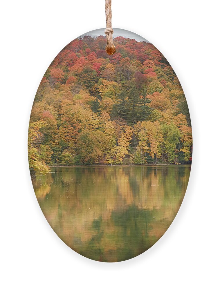 Abenaki Ornament featuring the photograph Vermont fall foliage reflected on Pogue Pond by Jeff Folger