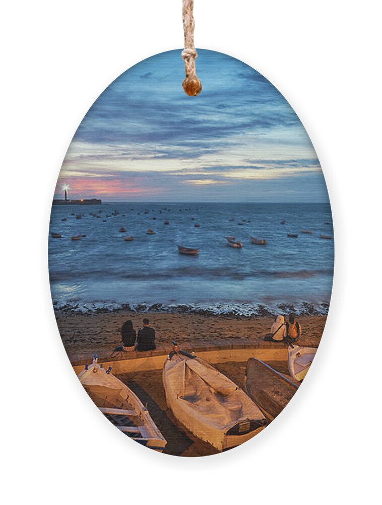 Sea Ornament featuring the photograph People at Caleta Beach Photographing Sunset Dramatic Sky Cadiz Andalusia Spain by Pablo Avanzini