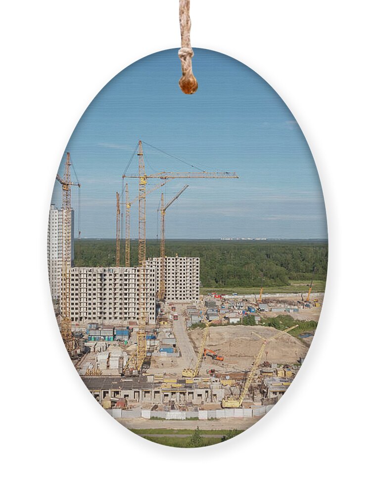 Crane Ornament featuring the photograph Building crane and buildings under construction by Mikhail Kokhanchikov