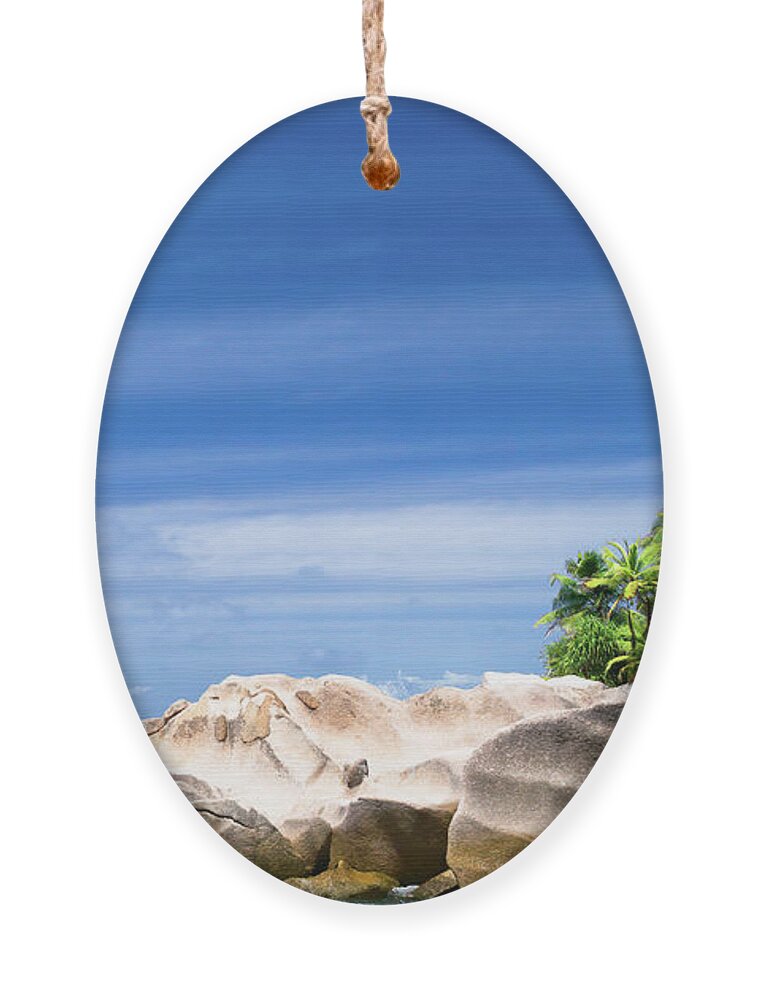 Bay Ornament featuring the photograph Coconut trees and rocks in the Seychelles by Jean-Luc Farges