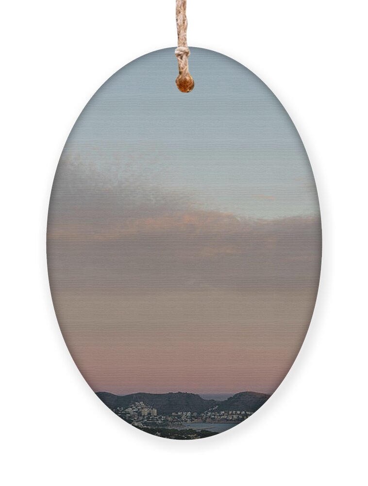 Mediterranean Coast Ornament featuring the photograph Pale pink sky and soft clouds at sunset on the Mediterranean coast by Adriana Mueller