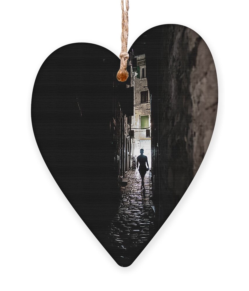  Ornament featuring the photograph Young Woman Walks Alone Through Spooky Narrow Abandoned Alley In The Night by Andreas Berthold