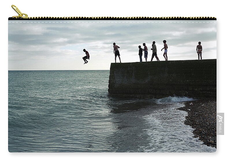 Child Zip Pouch featuring the photograph Boys Jumping Off A Pier On The Seafront by Fiona Crawford Watson