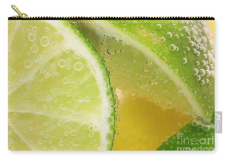 Lemon Zip Pouch featuring the photograph Lemon and lime slices in water by Simon Bratt