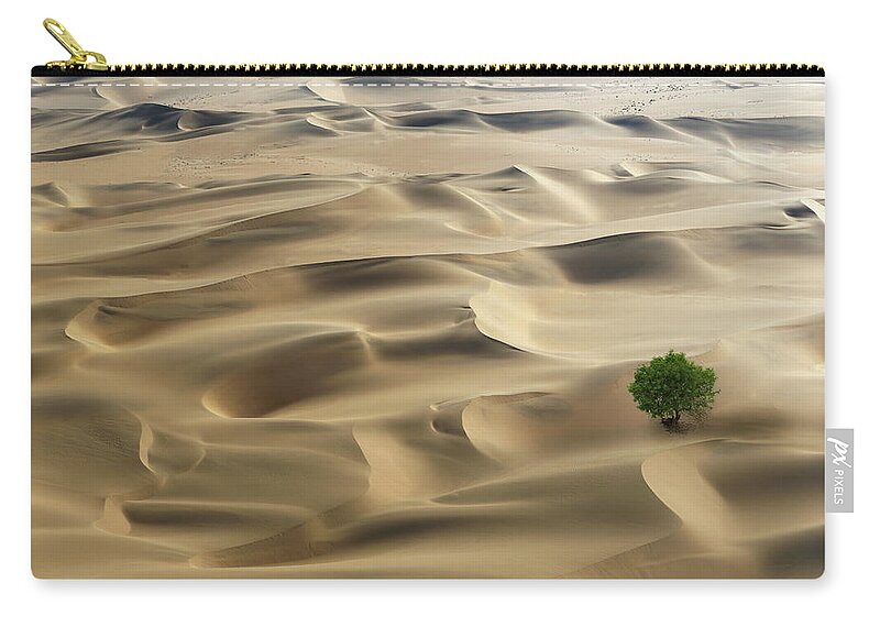 Tranquility Zip Pouch featuring the photograph Lone Tree In A Desert by Buena Vista Images