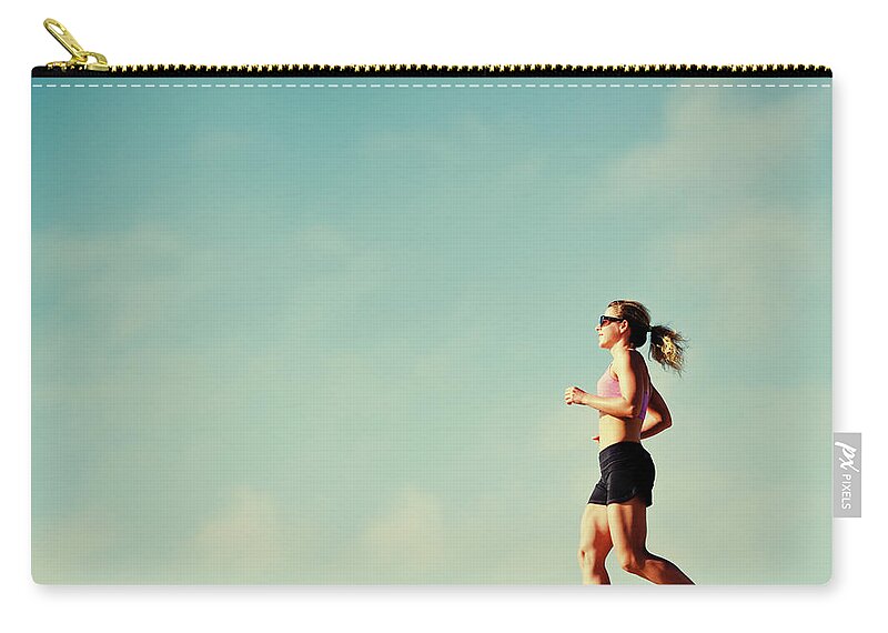 Mature Adult Zip Pouch featuring the photograph Mature Woman Jogging Outdoors by Anouchka