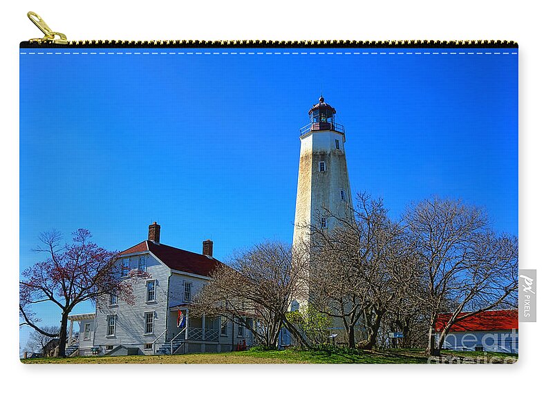 Sandy Zip Pouch featuring the photograph Sandy Hook Lighthouse and Keepers Quarters by Olivier Le Queinec
