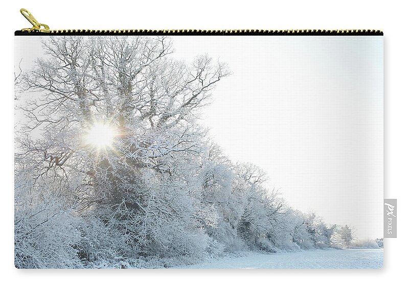 Tranquility Zip Pouch featuring the photograph Sunburst Through Trees In Winter by Dougal Waters