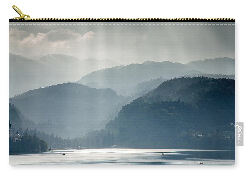 Bled Zip Pouch featuring the photograph Breaking through the mist by Ian Middleton