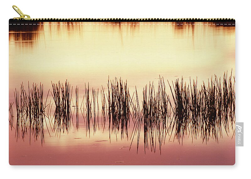 Mp Zip Pouch featuring the photograph Silhouette Of Grass Against Reflection by Gerry Ellis