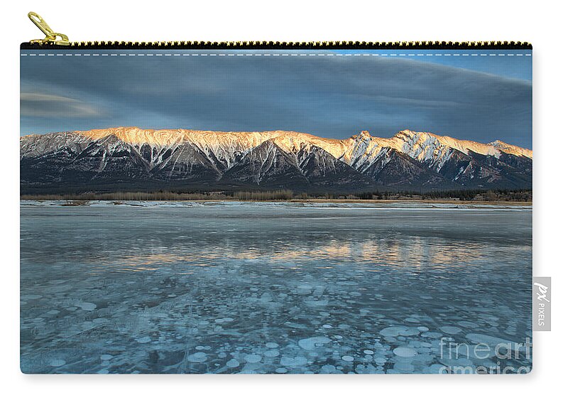 Abraham Lake Zip Pouch featuring the photograph Abraham Lake Ice Bubble Sunset by Adam Jewell