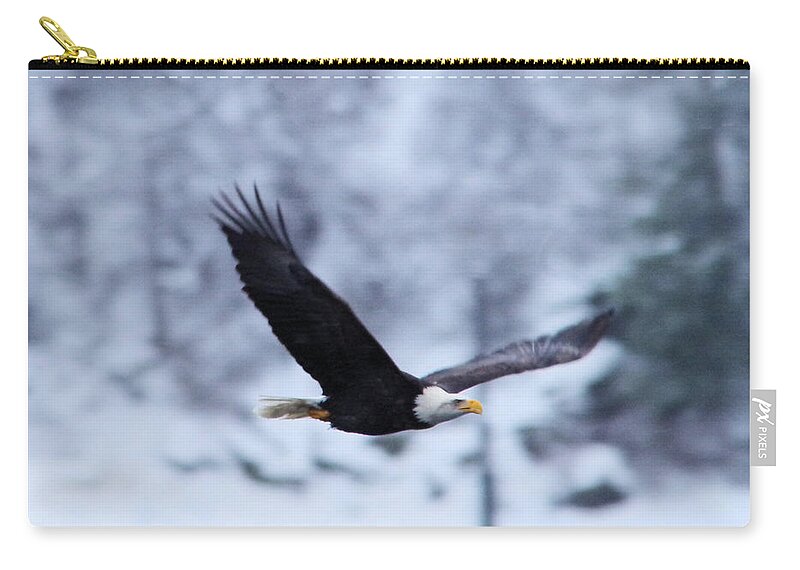 Eagle Zip Pouch featuring the photograph An eagle through th snowy air by Jeff Swan