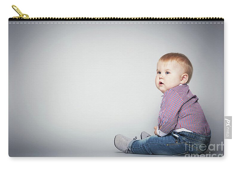 Baby Zip Pouch featuring the photograph Cute toddler sitting on the floor. by Michal Bednarek