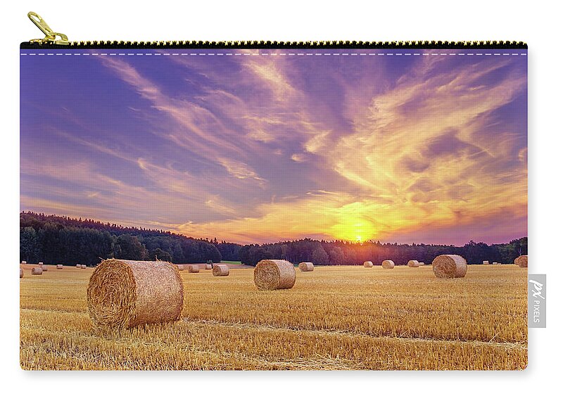 Europe Zip Pouch featuring the photograph Hay bales and the setting sun by Dmytro Korol