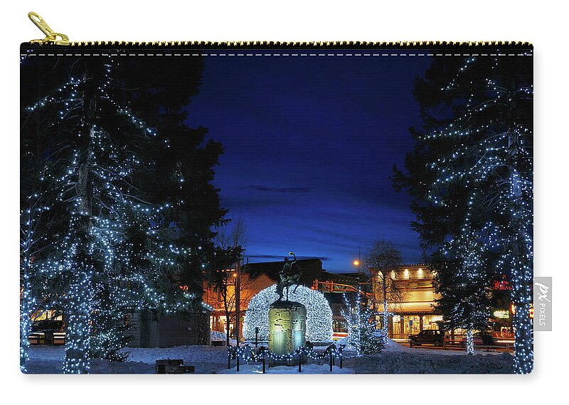 Bright Zip Pouch featuring the photograph Lights on Elk antler arches and trees in Jackson Wyoming town sq by Reimar Gaertner