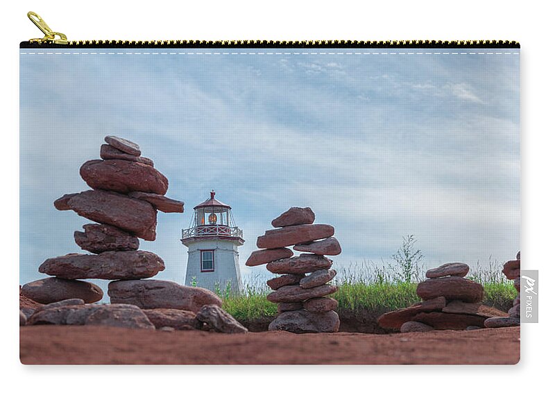 Cairns Zip Pouch featuring the photograph North Cape Lighthouse behind Stone Cairns by Chris Bordeleau