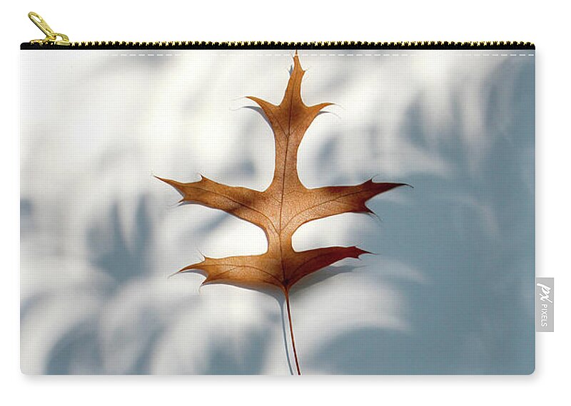 Light Zip Pouch featuring the photograph Solar Eclipse Crescents over Oak Leaf by Adam Long