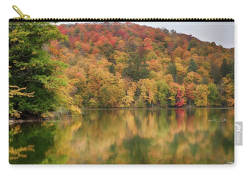 Abenaki Zip Pouch featuring the photograph Vermont fall foliage reflected on Pogue Pond by Jeff Folger