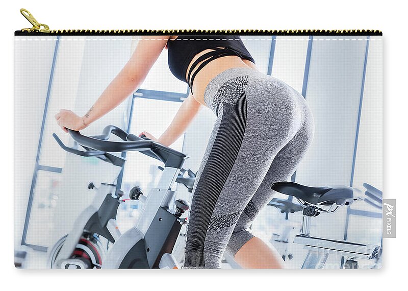 Gym Zip Pouch featuring the photograph Young woman during spinning class. by Michal Bednarek