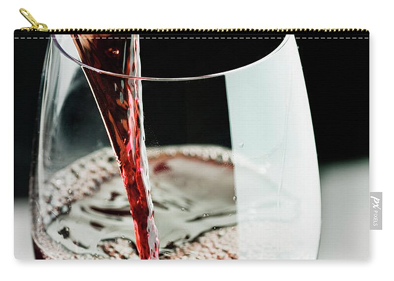 Alcohol Zip Pouch featuring the photograph Red Wine Being Poured In A Glass #1 by Juanmonino