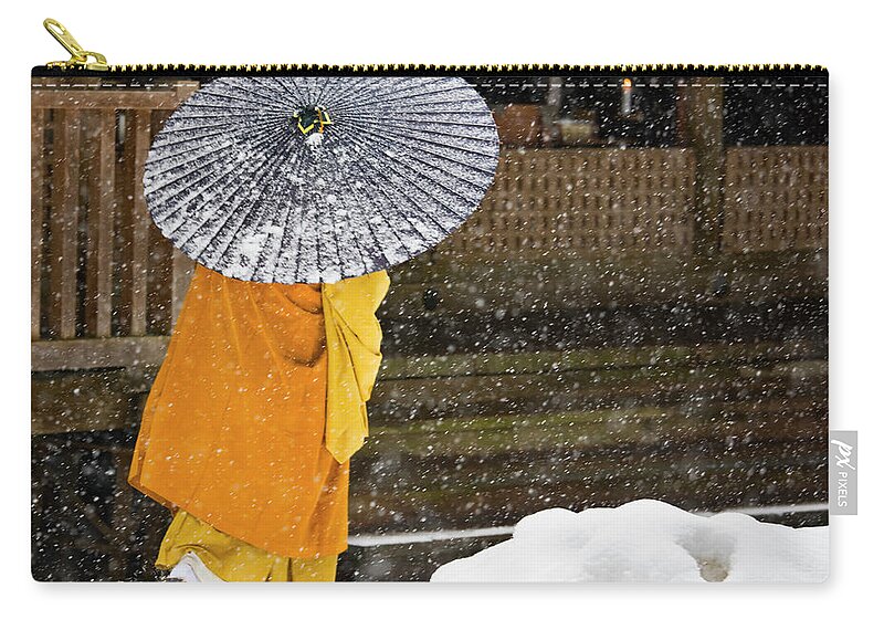 Shingon Buddhism Zip Pouch featuring the photograph A Buddhist Monk Walks Through A Snow by Mint Images - Art Wolfe