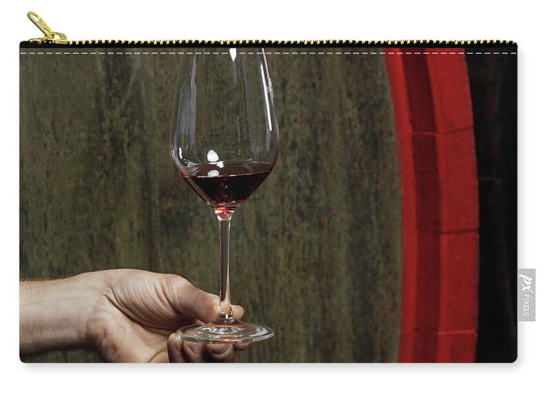 Mature Adult Zip Pouch featuring the photograph A Human Hand Holding A Glass Of Red Wine by Hudzilla