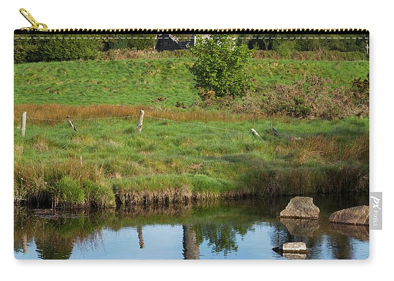 Tranquility Zip Pouch featuring the photograph A Round Tower With The Reflection In A by Peter Zoeller / Design Pics