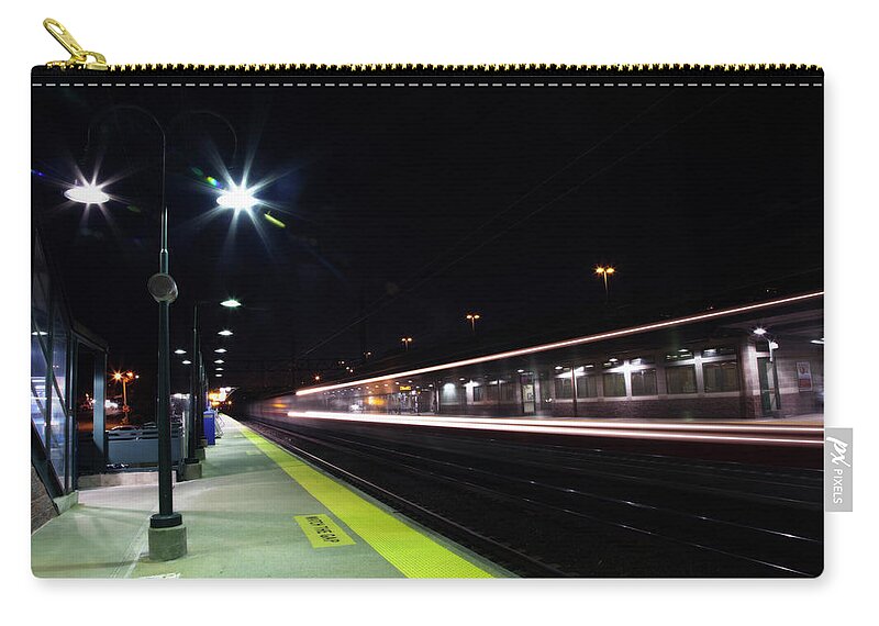 Train Zip Pouch featuring the photograph A Train Going Through A Station At Night by Elisabeth Pollaert Smith