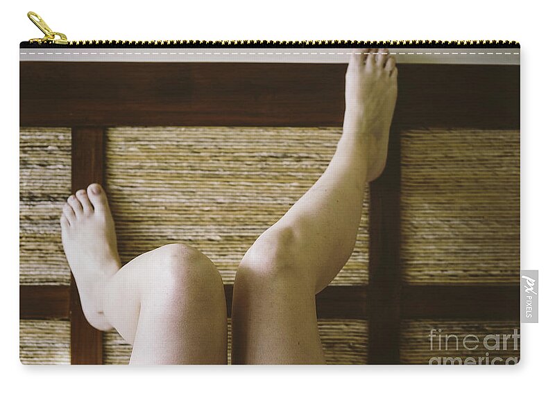 Adult Zip Pouch featuring the photograph Bare feet of woman leaning on the headboard of her bed in a sexy way. by Joaquin Corbalan