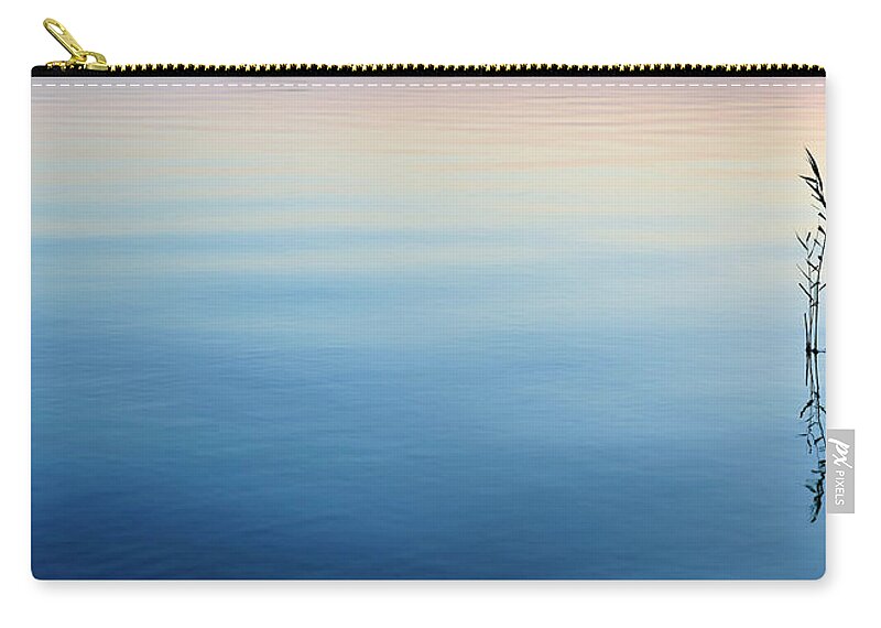 Water's Edge Zip Pouch featuring the photograph Blades Of Reed In Tranquil Calm Lake At by Avtg