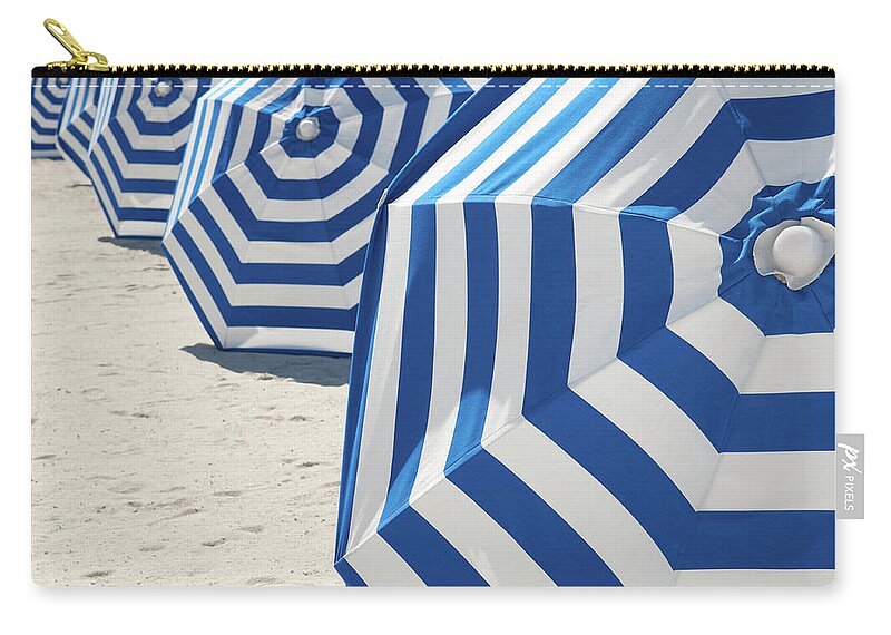 In A Row Zip Pouch featuring the photograph Bright Blue And White Striped Beach by Peskymonkey