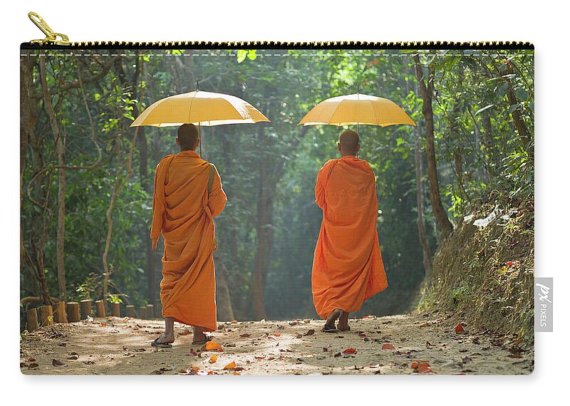 Young Men Zip Pouch featuring the photograph Buddhist Monks Walking Along Dirt Road by Martin Puddy