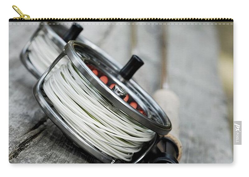 Two Objects Zip Pouch featuring the photograph Close-up Of Two Fishing Reels And A by Glowimages